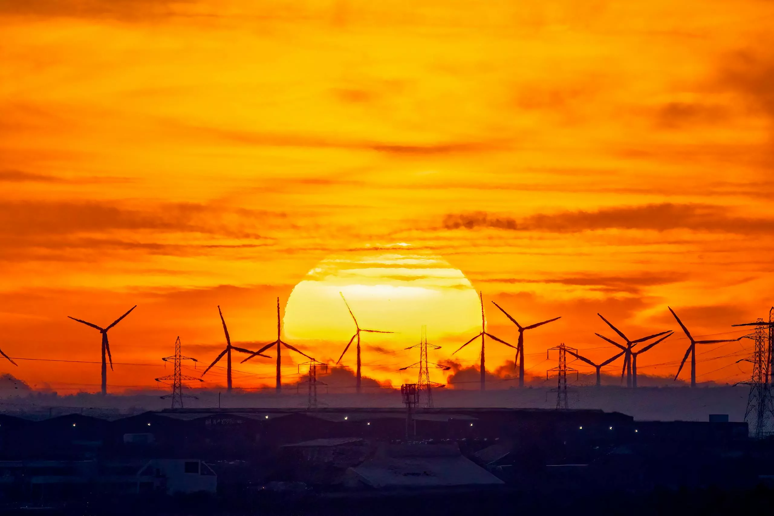 Silhouette of wind turbines at sunset, showcasing sustainable energy solutions.
